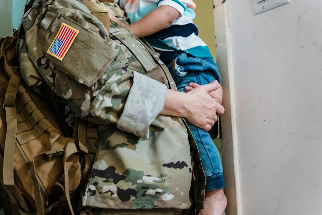 Military father holding young son in his arms.
